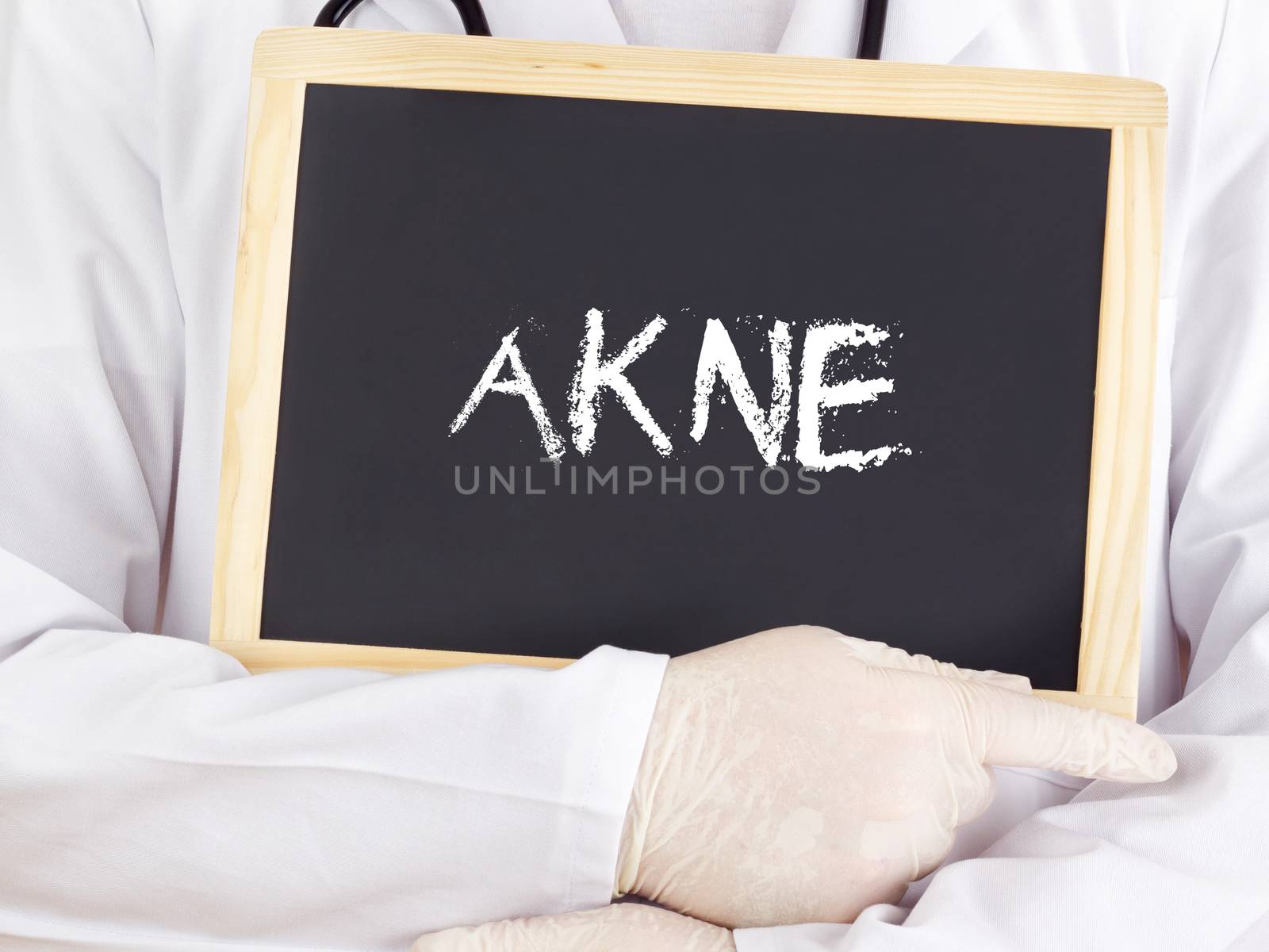 Doctor shows information on blackboard: acne in german by gwolters