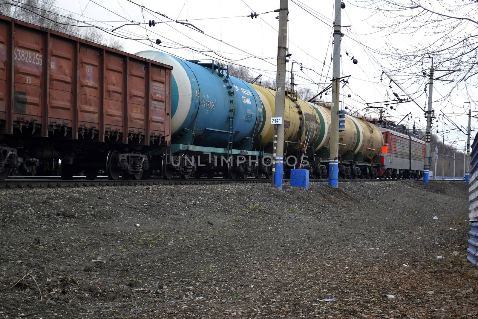 The cargo train with tanks moves on railway tracks