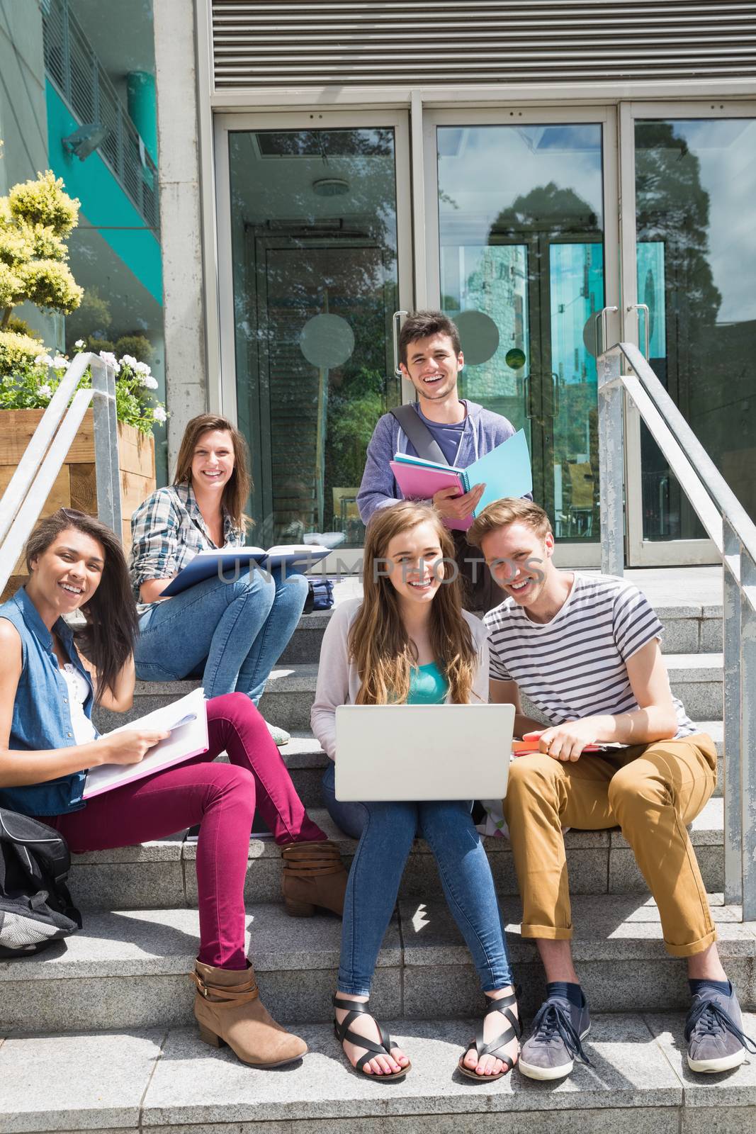 Students sitting on steps studying by Wavebreakmedia