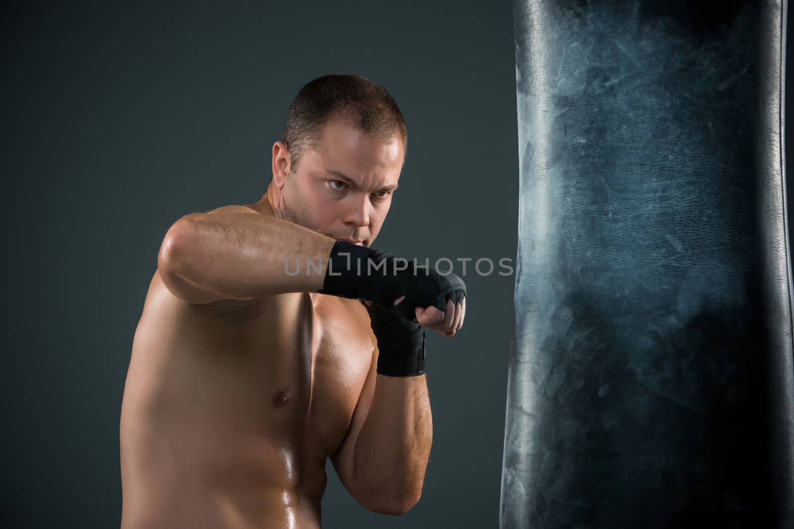 Young boxer boxing over  the black background