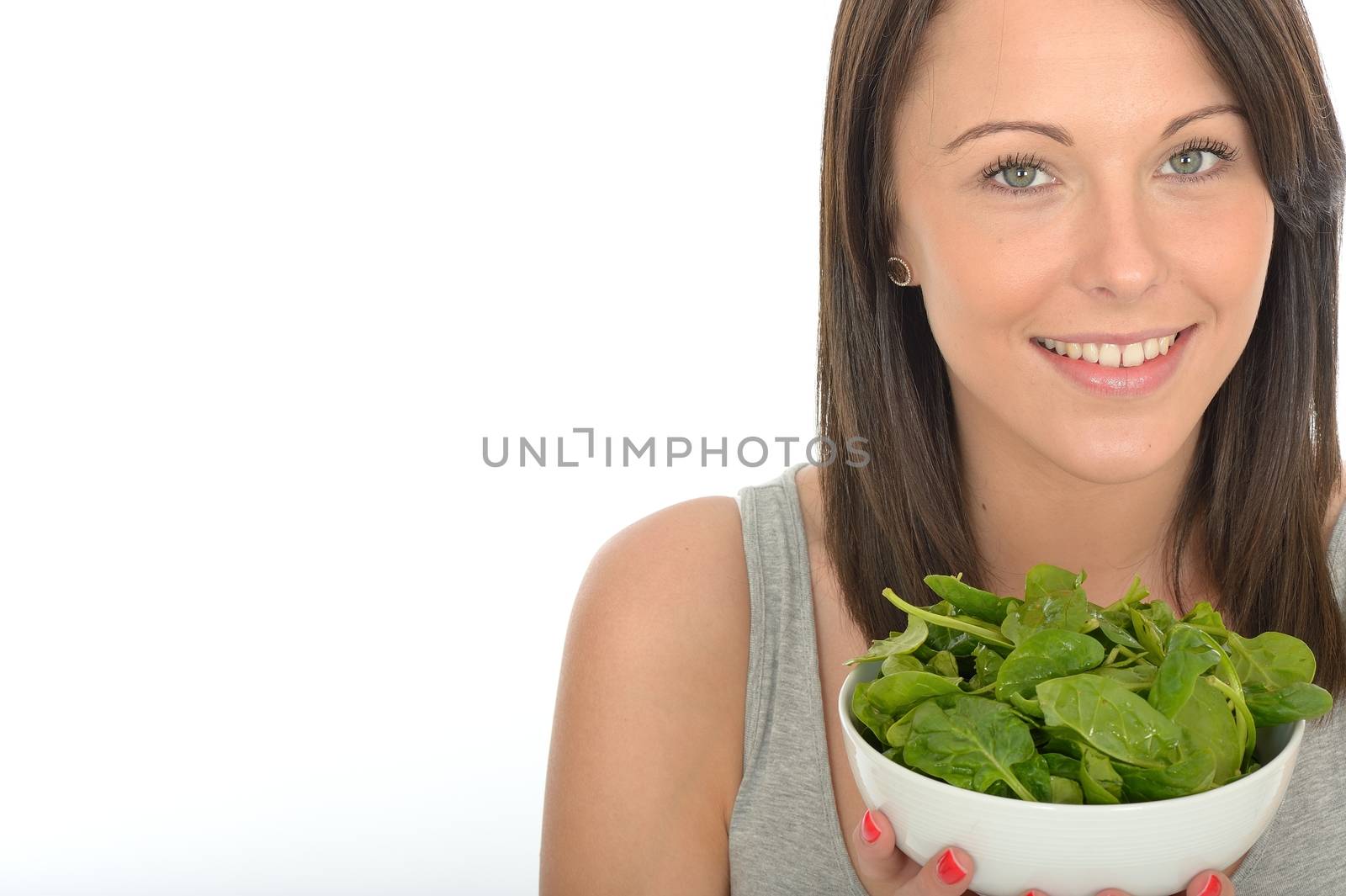 Attractive Healthy Young Woman Holding A Bowl of Spinach by Whiteboxmedia