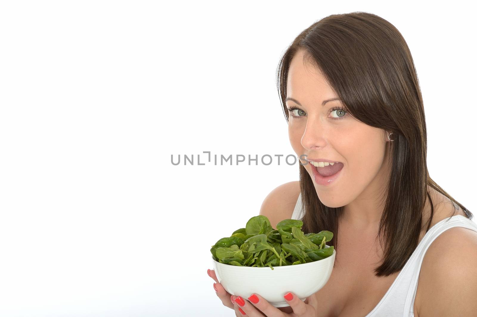 Happy Attractive Young Woman Holding a Plate of Fresh Spinach by Whiteboxmedia