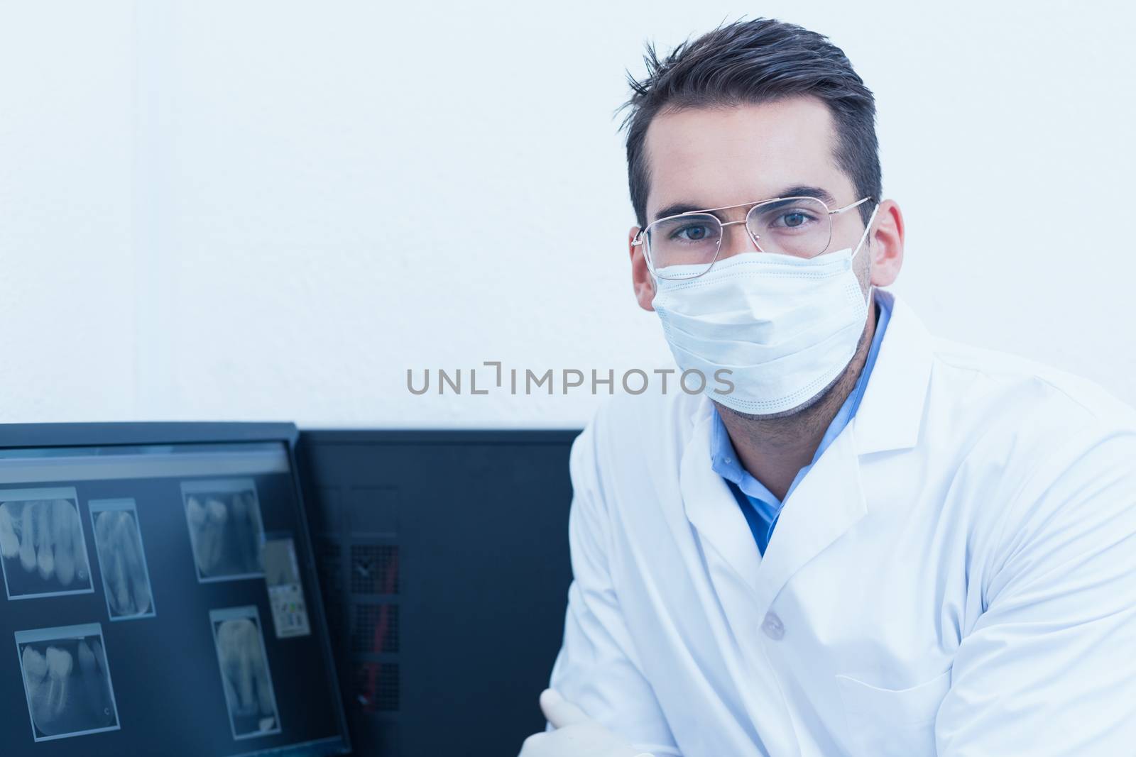 Dentist wearing surgical mask by Wavebreakmedia