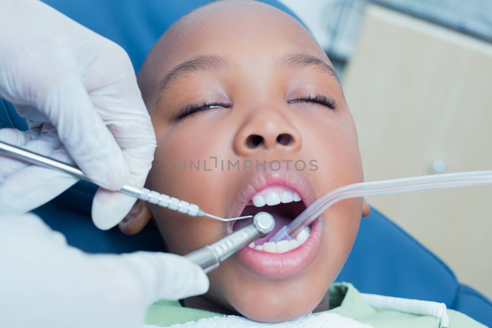 Boy having his teeth examined by dentist by Wavebreakmedia