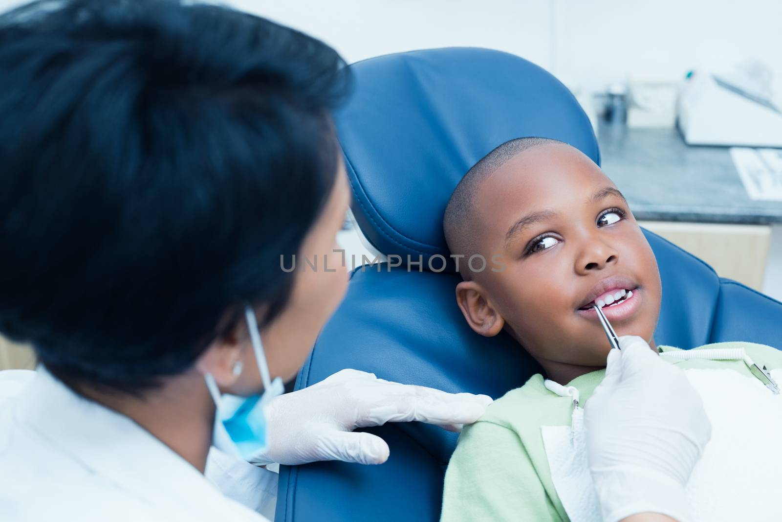 Close up of dentist examining a boys teeth in the dentists chair