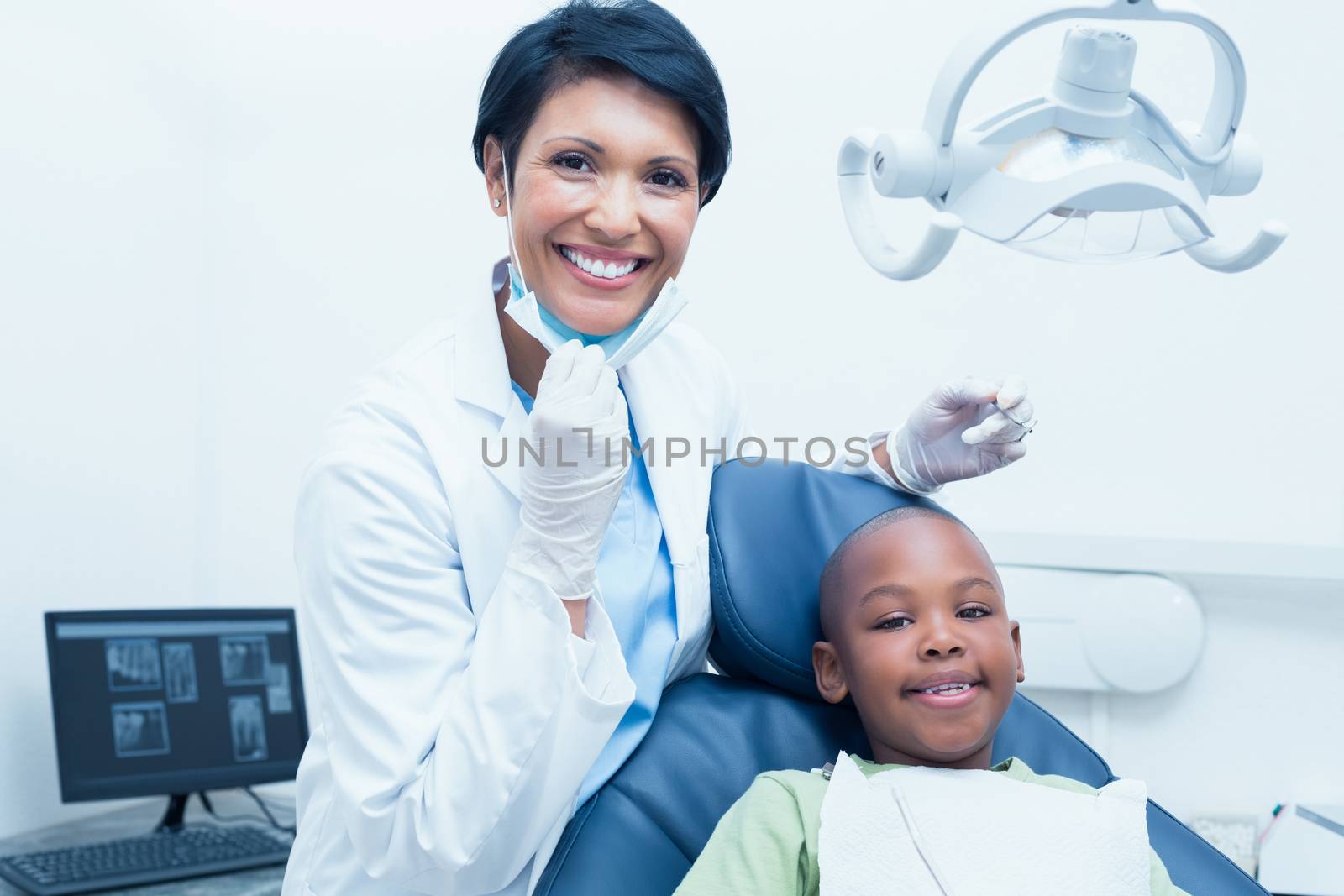 Portrait of smiling female dentist examining boys teeth by Wavebreakmedia