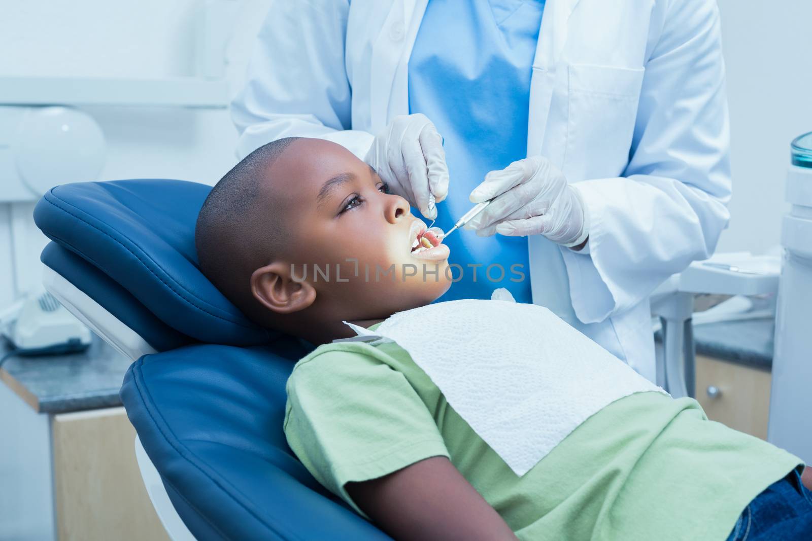 Side view of boy having his teeth examined by a dentist