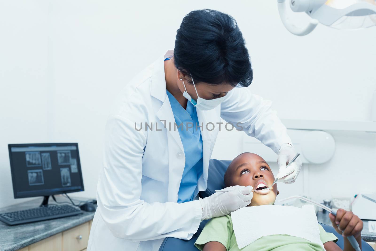 Female dentist examining boys teeth by Wavebreakmedia