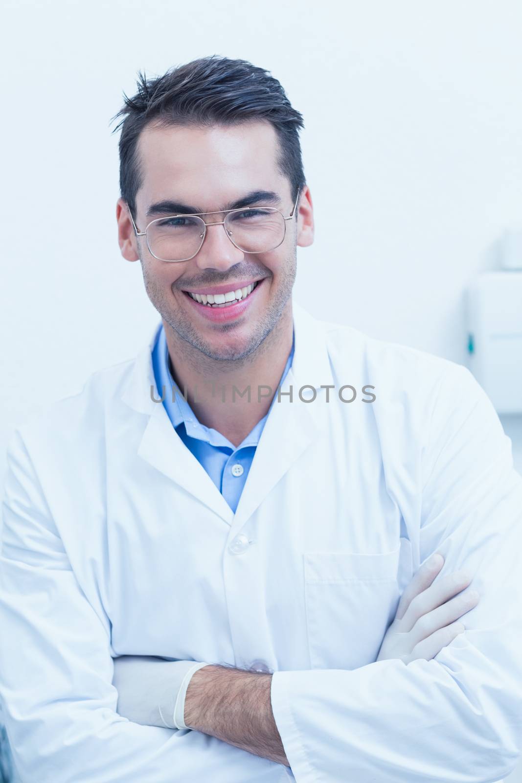 Portrait of happy male dentist with arms crossed