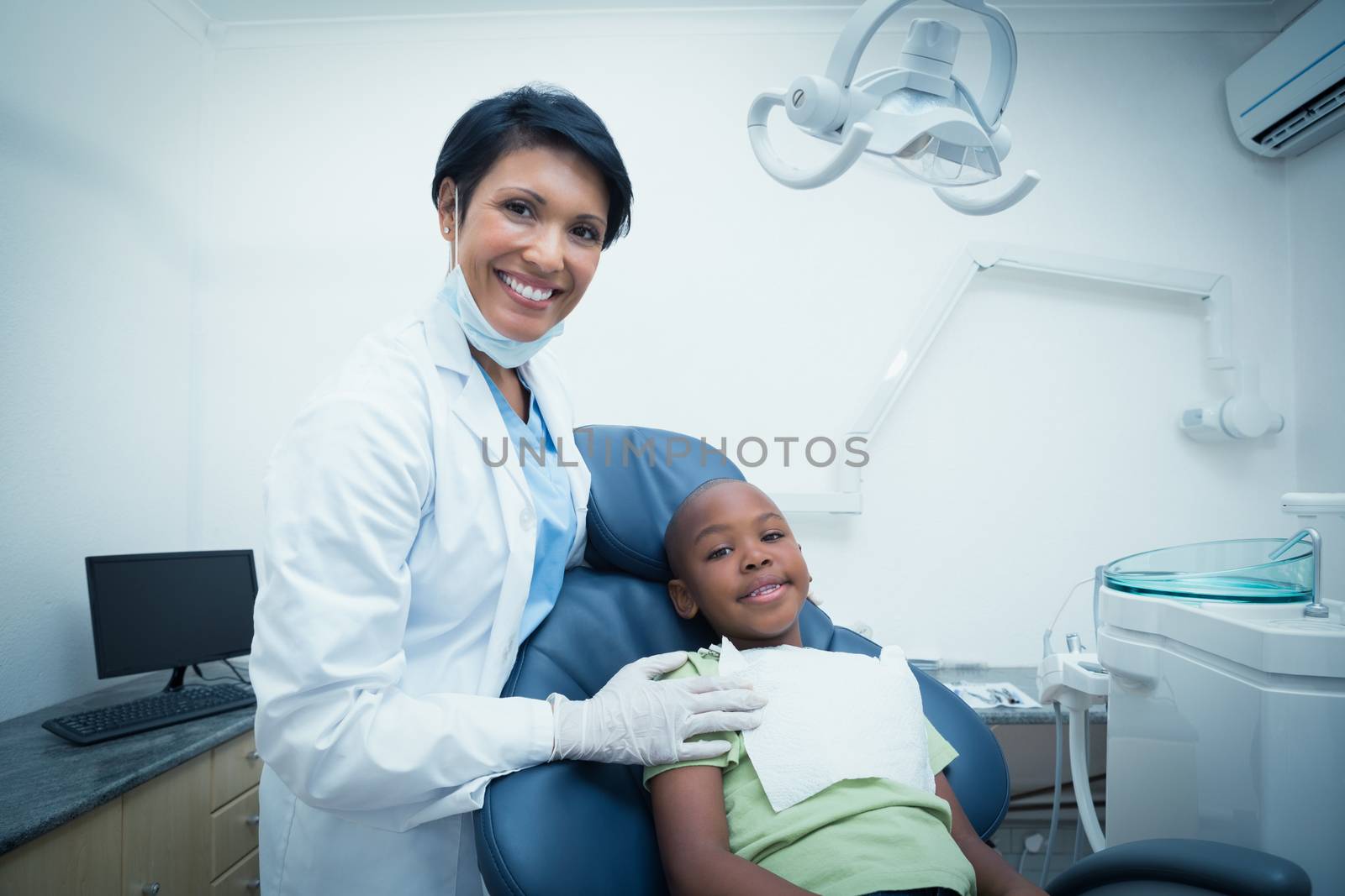 Portrait of smiling female dentist examining boys teeth by Wavebreakmedia