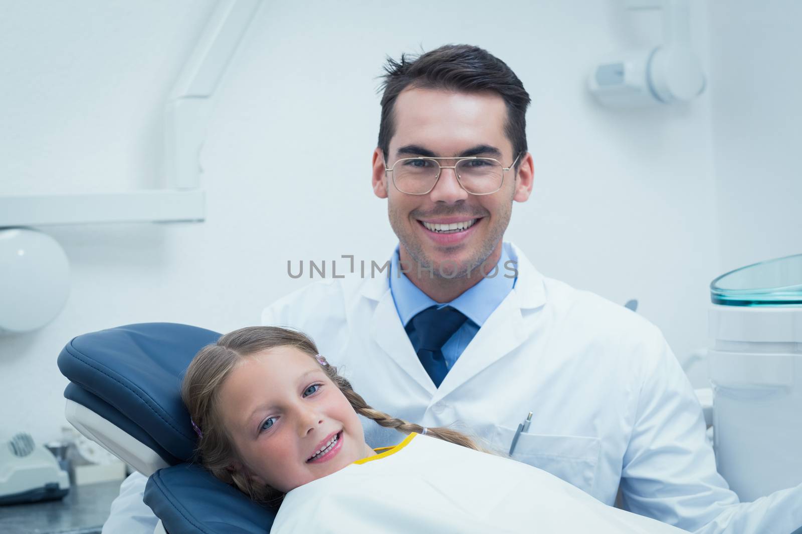 Male dentist examining girls teeth by Wavebreakmedia