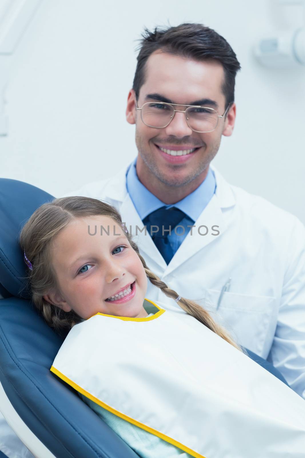 Male dentist examining girls teeth by Wavebreakmedia