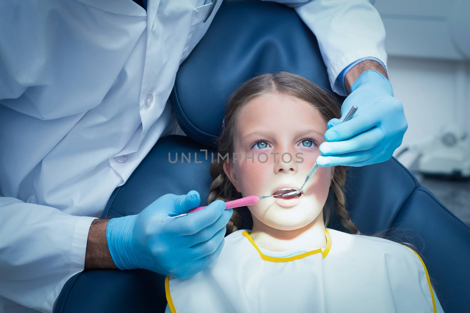 Male dentist examining girls teeth by Wavebreakmedia