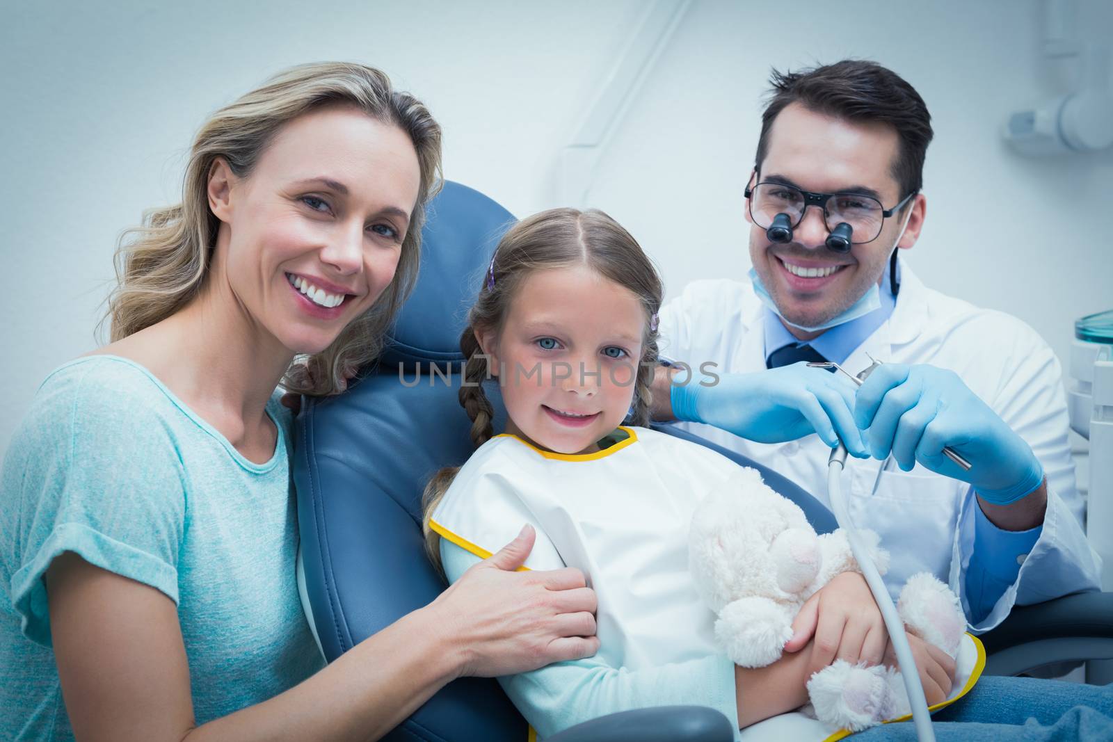 Dentist examining girls teeth with assistant by Wavebreakmedia