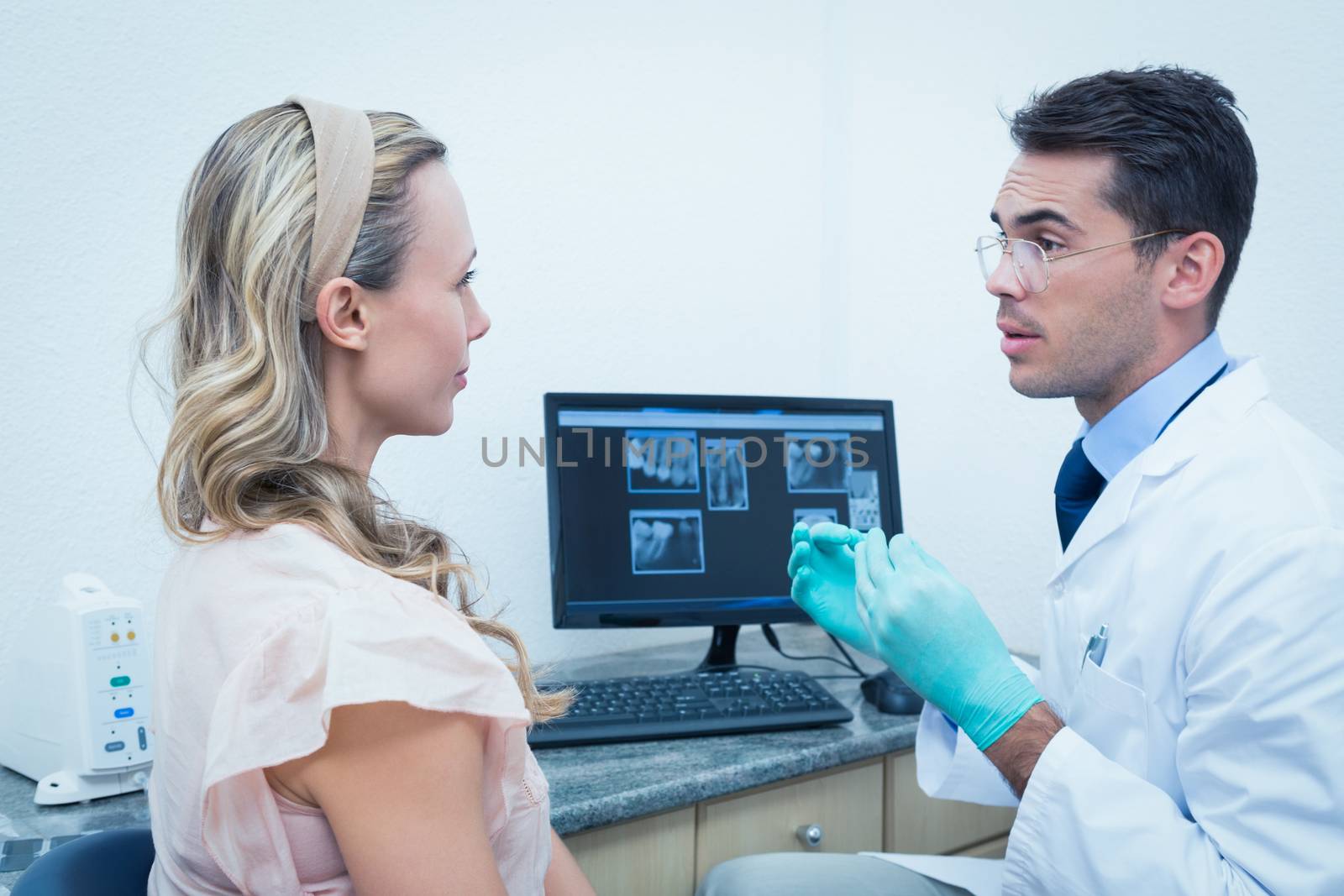 Dentist showing woman her mouth x-ray on computer by Wavebreakmedia