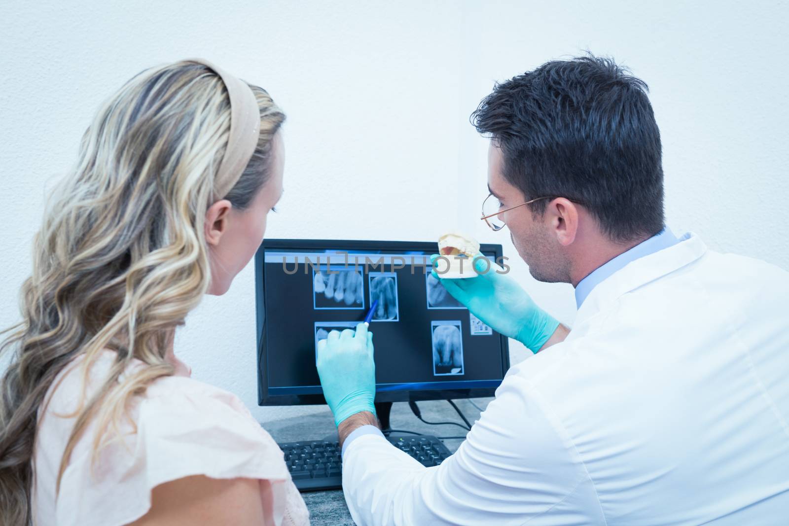 Dentist showing woman prosthesis teeth by Wavebreakmedia