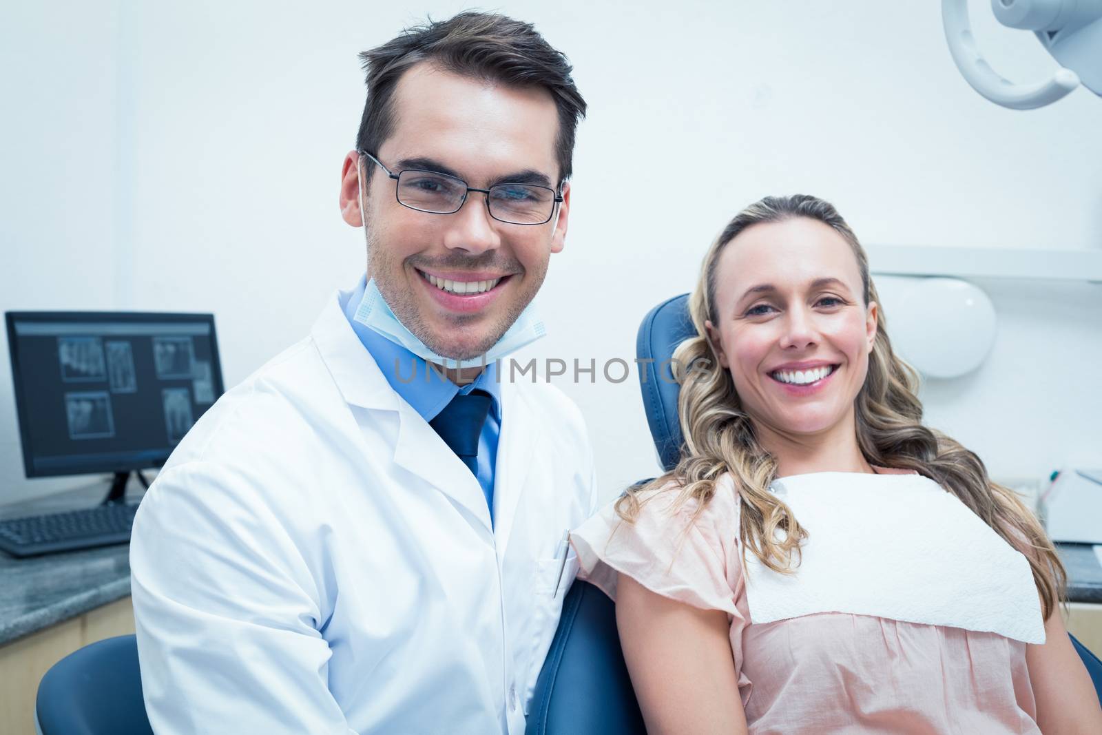 Dentist examining young womans teeth in the dentists chair