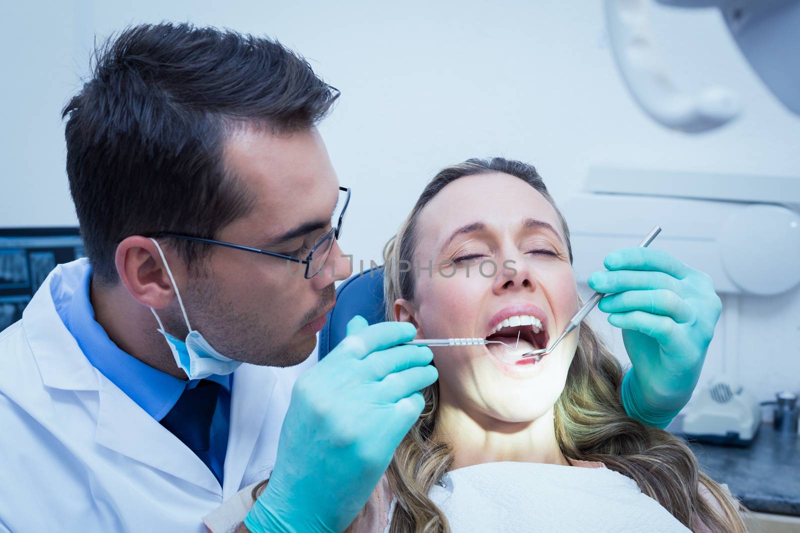 Dentist examining young womans teeth by Wavebreakmedia