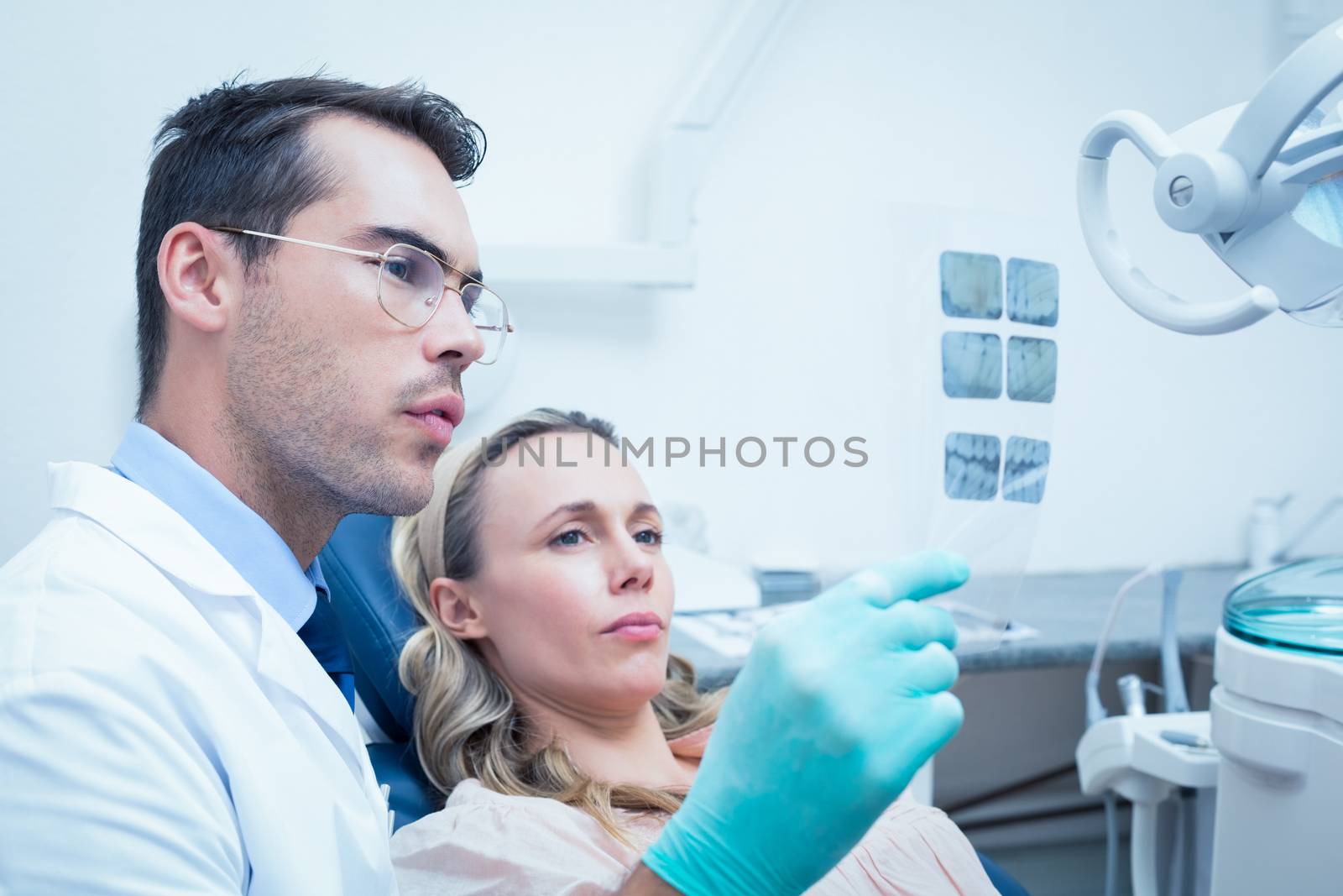 Dentist showing woman her mouth x-ray by Wavebreakmedia