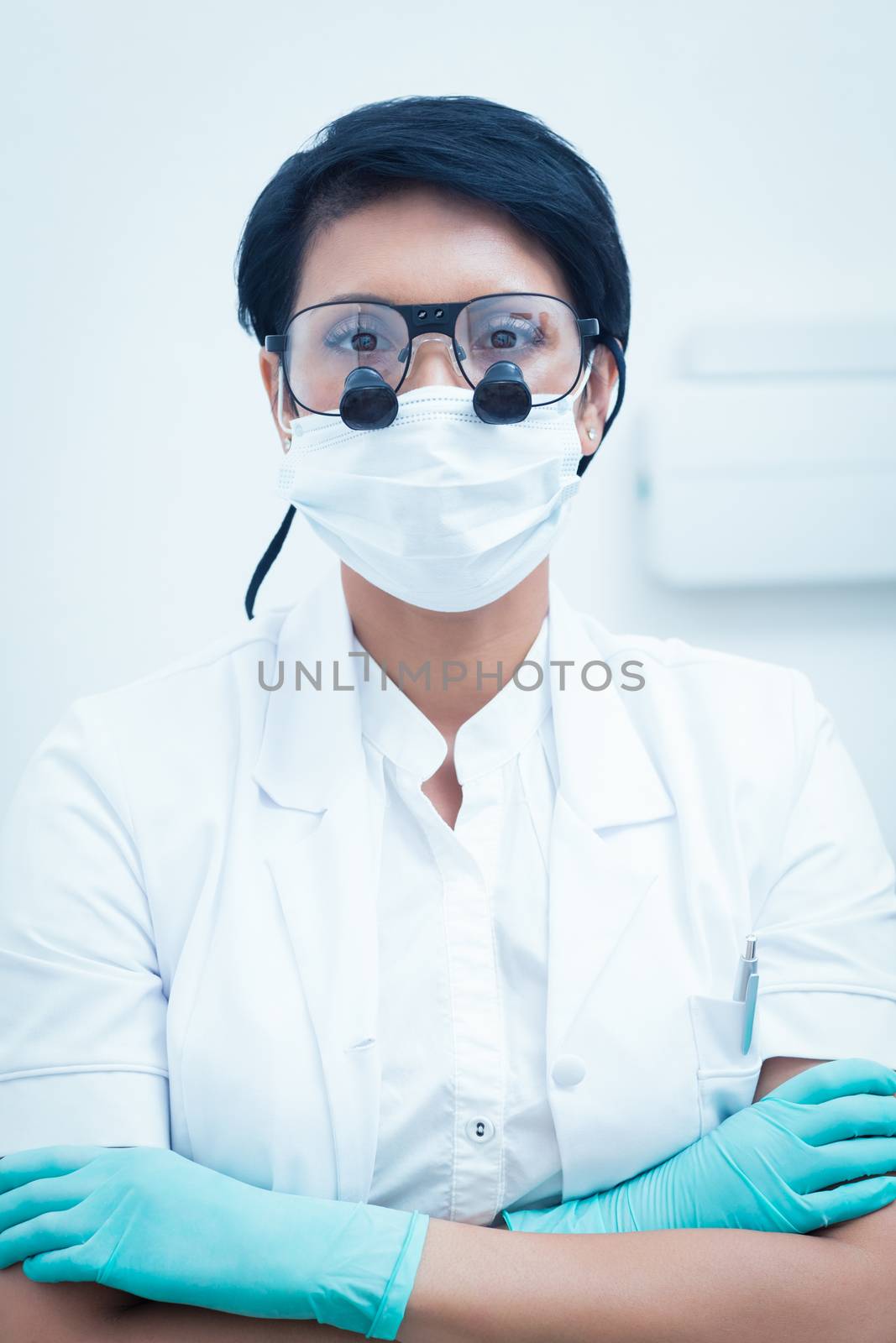 Female dentist wearing surgical mask and dental loupes by Wavebreakmedia