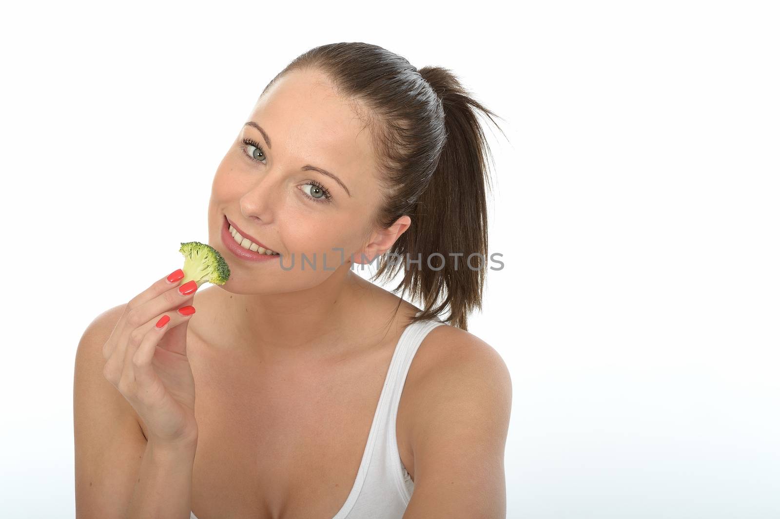 Attractive Young Woman Eating Raw Broccoli by Whiteboxmedia