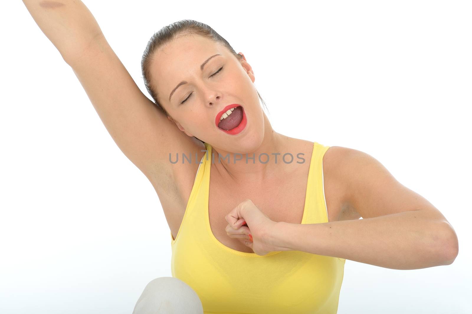 Attractive Young Woman Stretching and Yawning Wearing a Bright Yellow Vest Top