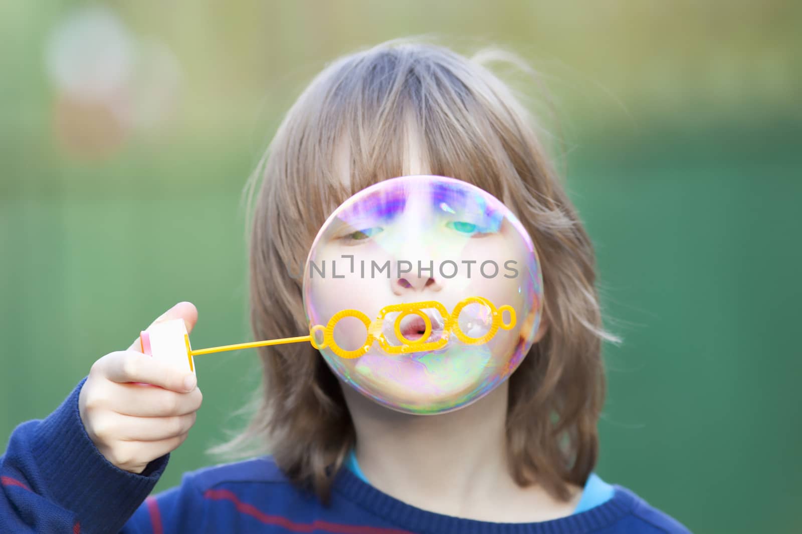 Boy with Blond Hair Blowing Bubbles Outdoor