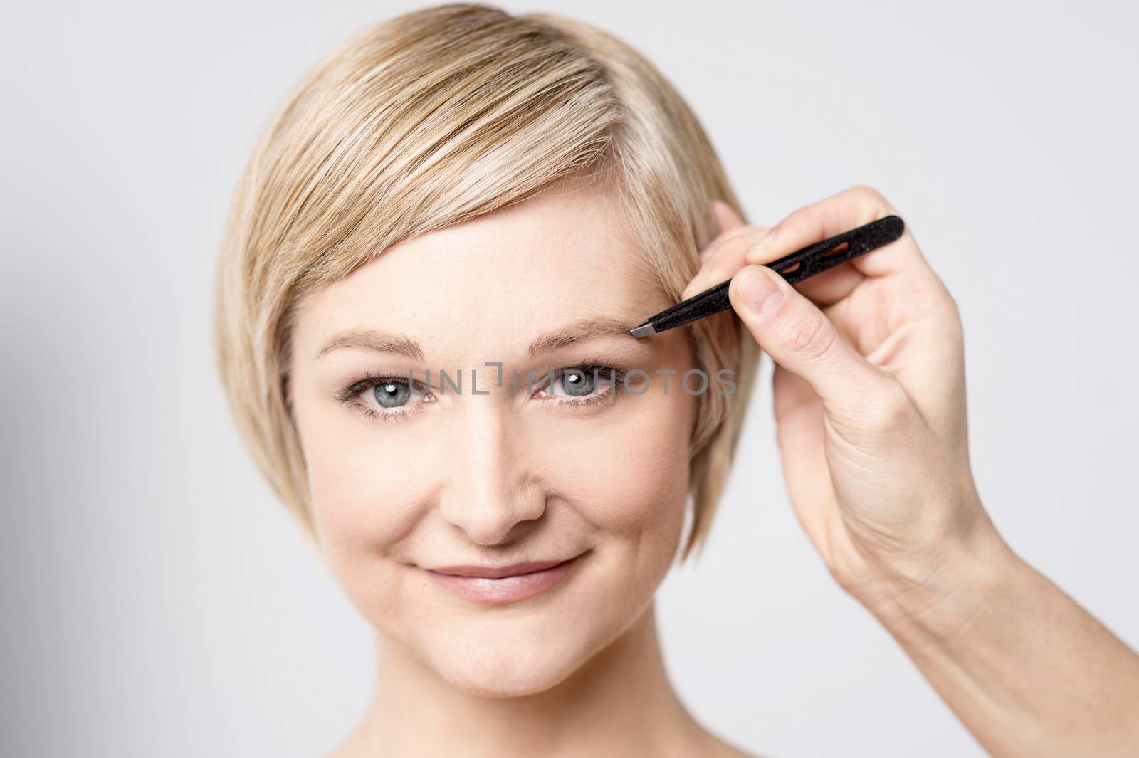 Close up of mid woman brushing her eyebrow