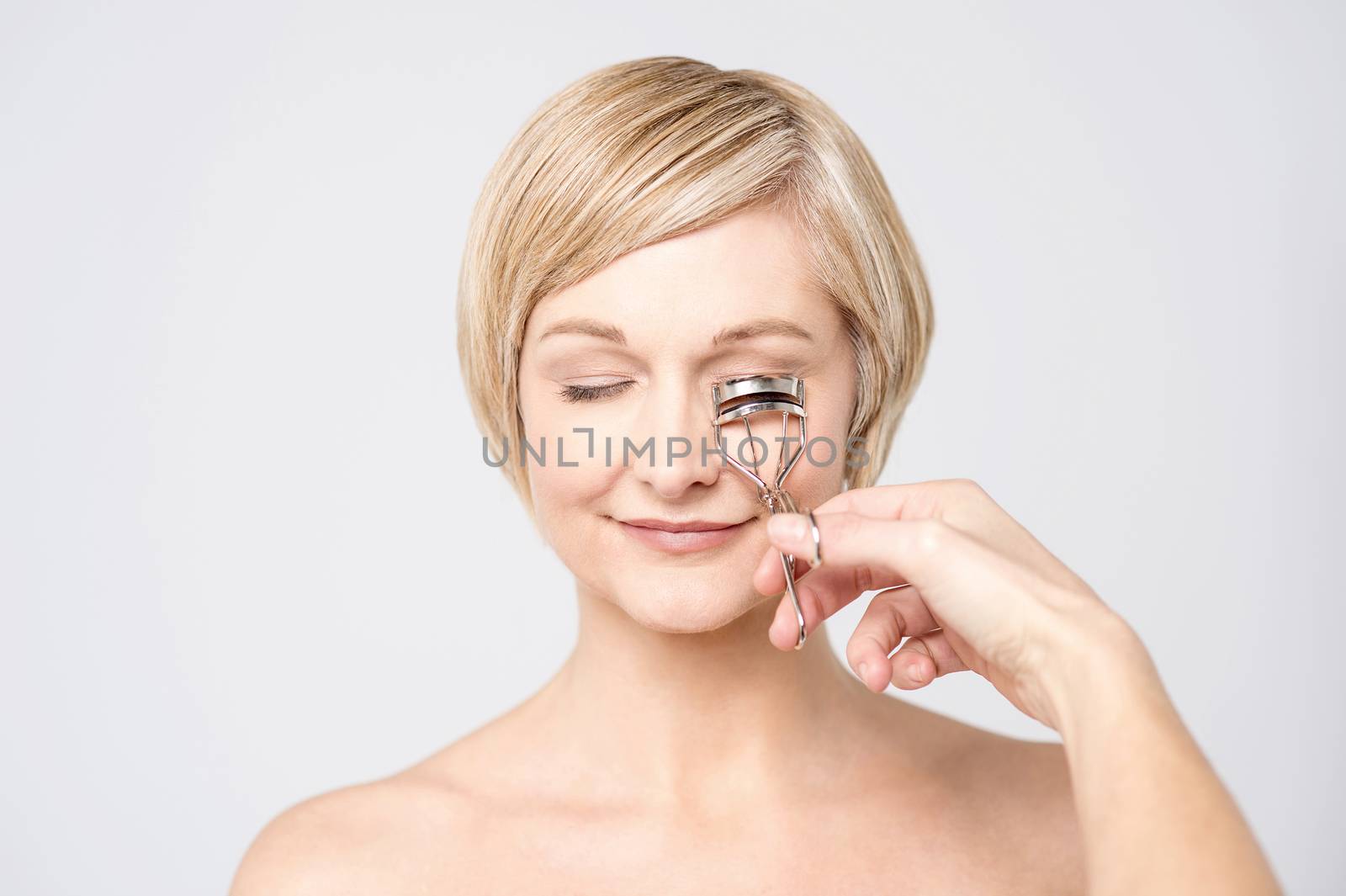 Happy woman cutting her eye lashes