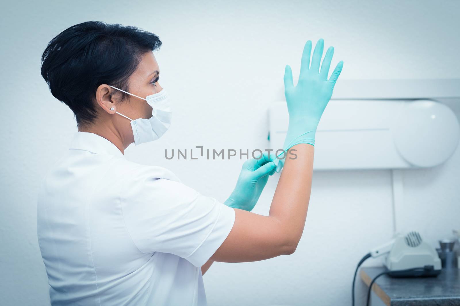 Side view of female dentist wearing surgical glove