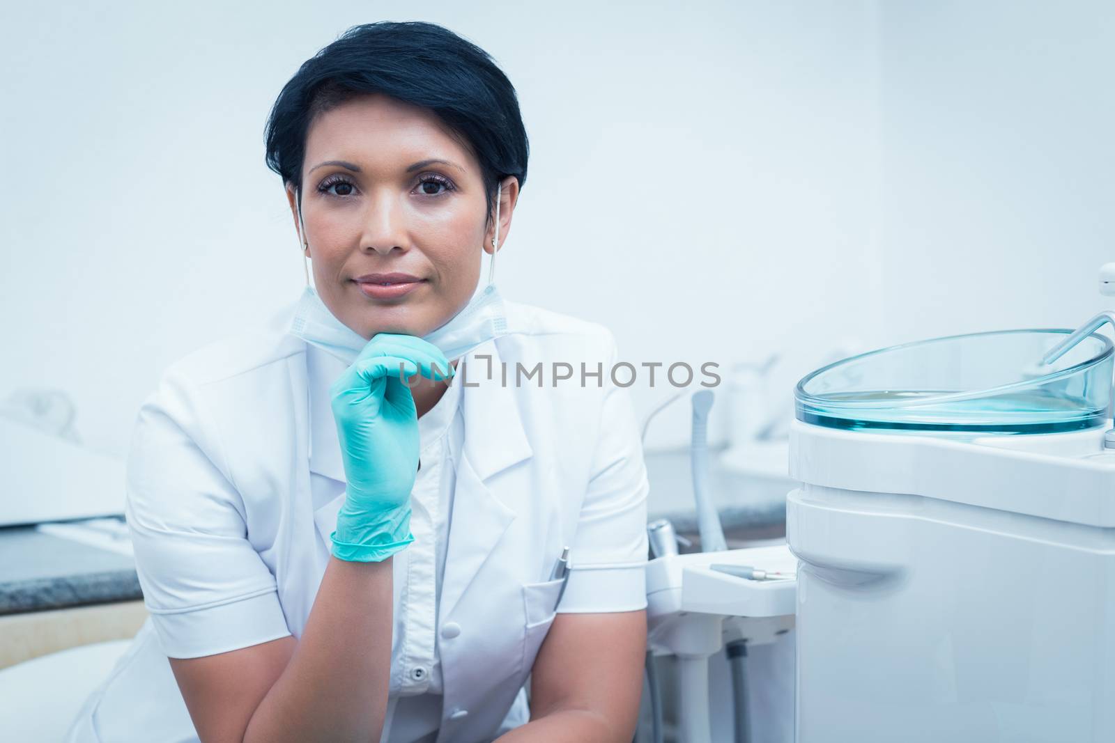 Portrait of confident female dentist with hand on chin