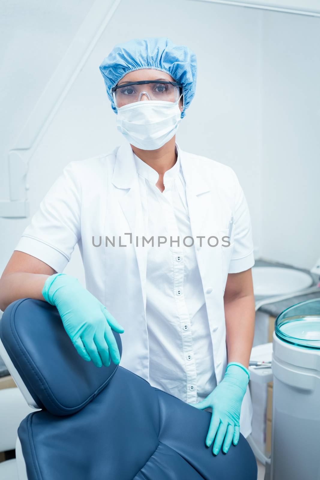 Portrait of female dentist wearing surgical mask and safety glasses