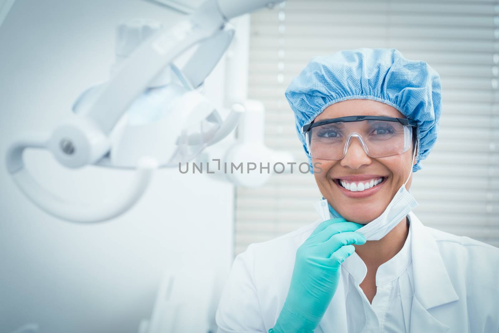 Portrait of female dentist wearing surgical cap and safety glasses