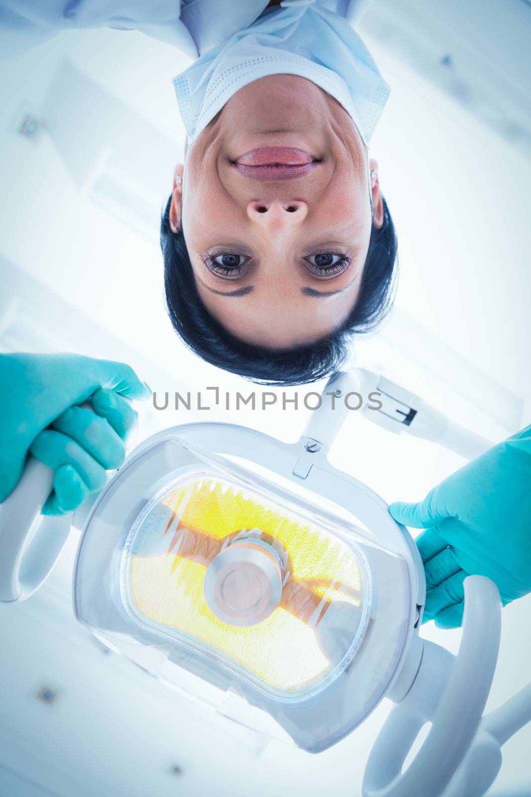 Low angle of female dentist adjusting light by Wavebreakmedia