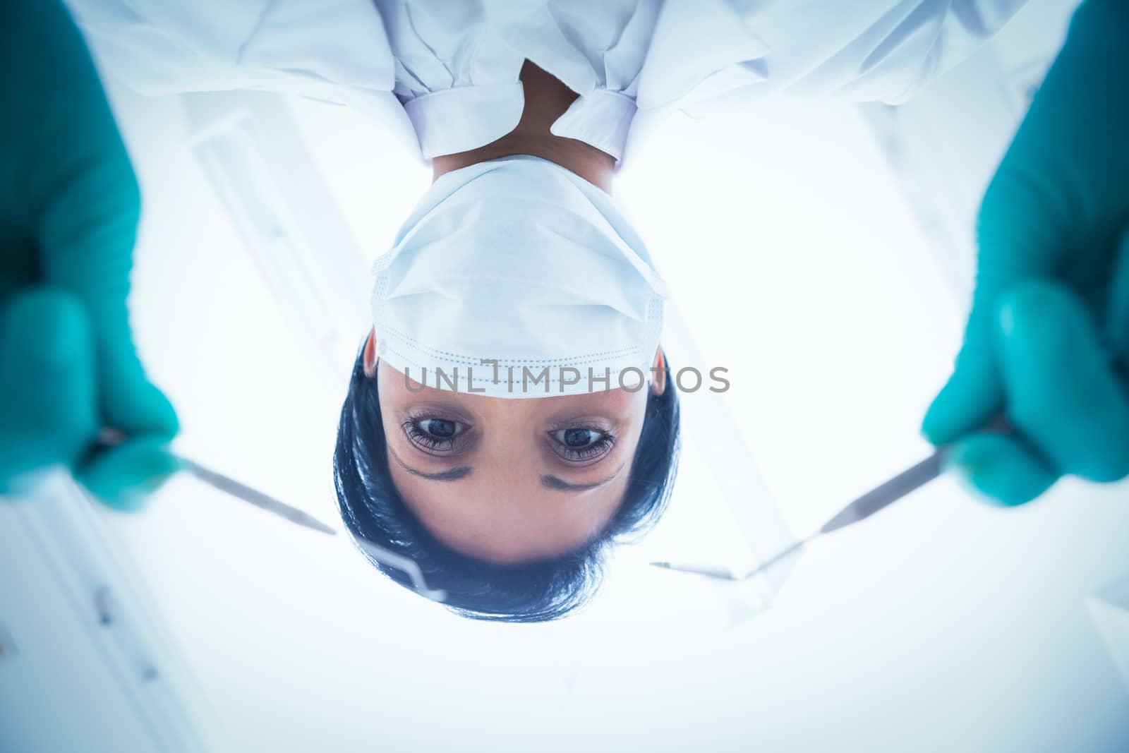Female dentist in surgical mask holding dental tools by Wavebreakmedia