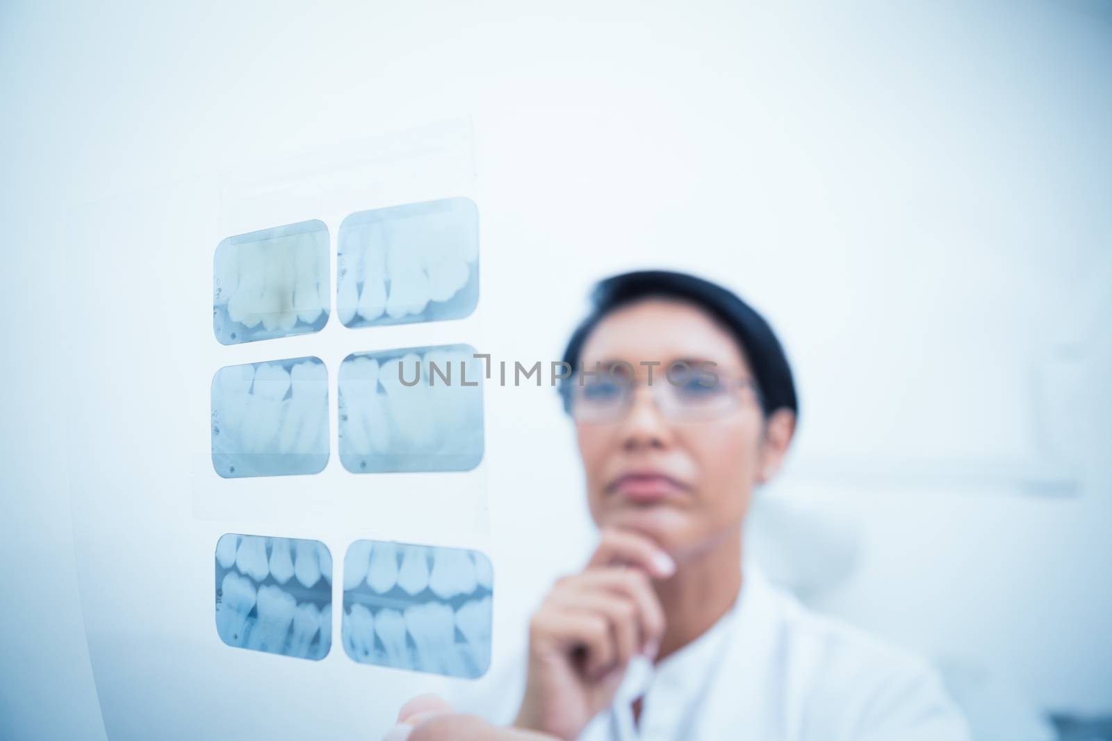 Concentrated dentist looking at x-ray by Wavebreakmedia