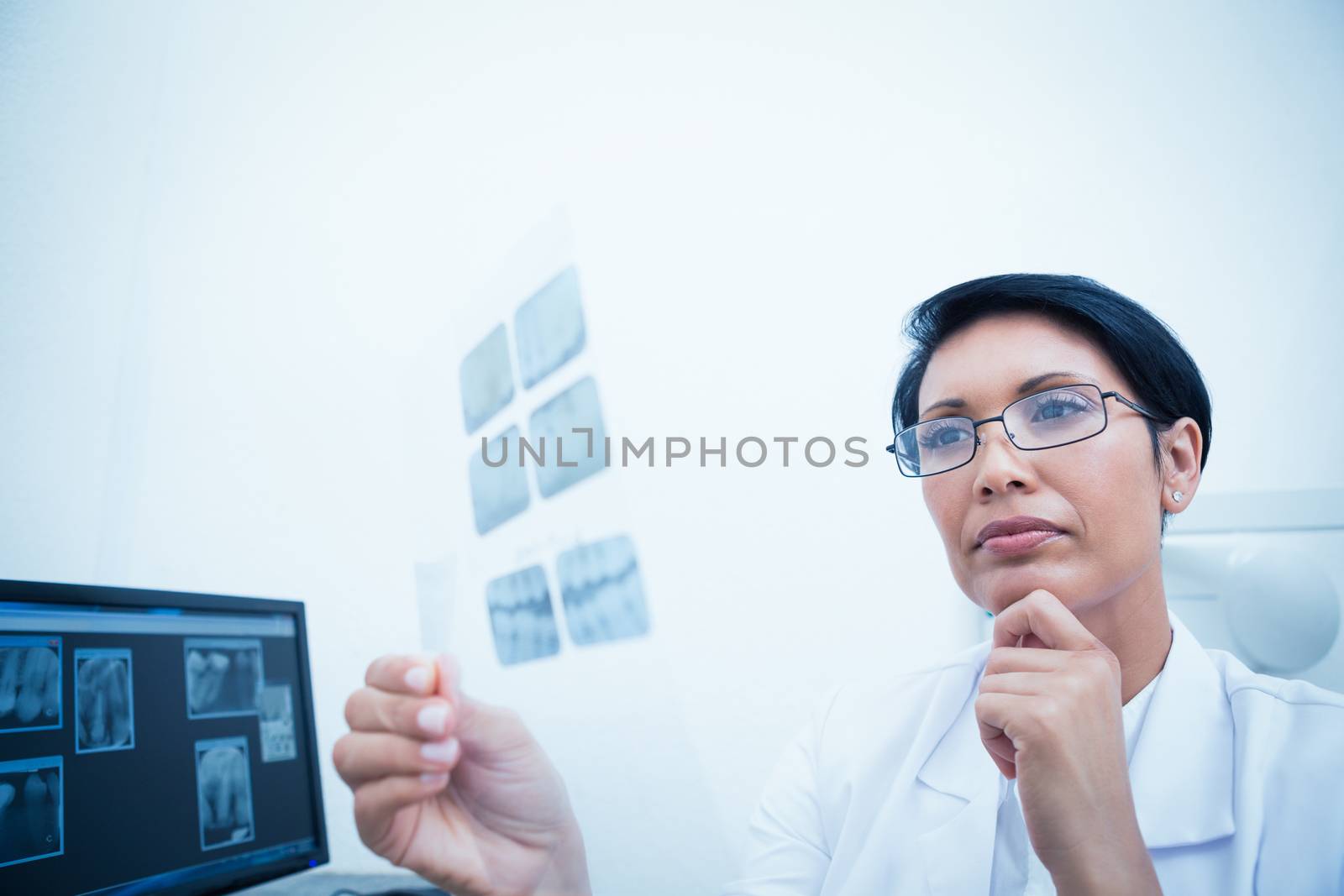 Female dentist looking at x-ray by Wavebreakmedia
