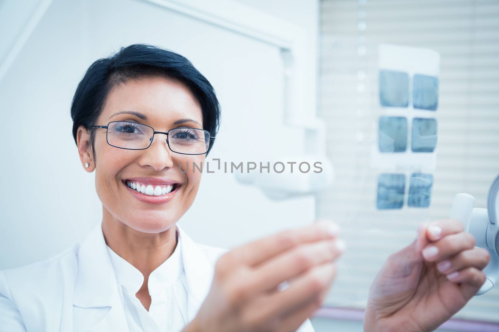 Portrait of happy female dentist holding x-ray