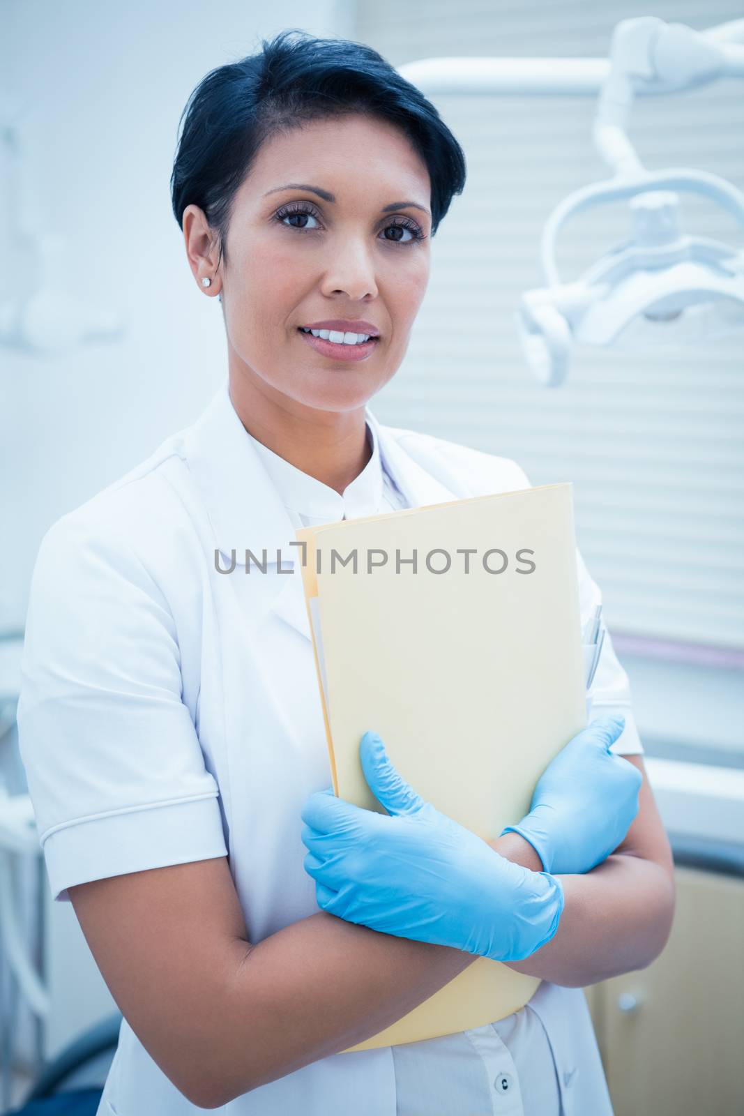 Female dentist holding reports by Wavebreakmedia