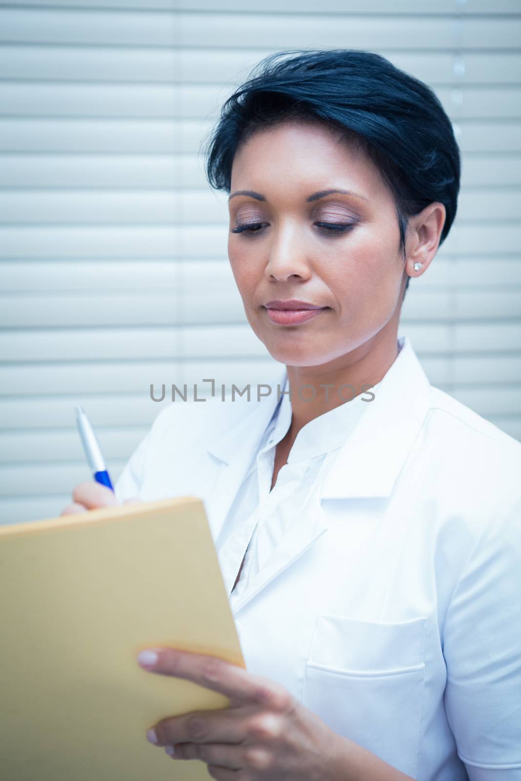 Serious female dentist reading reports