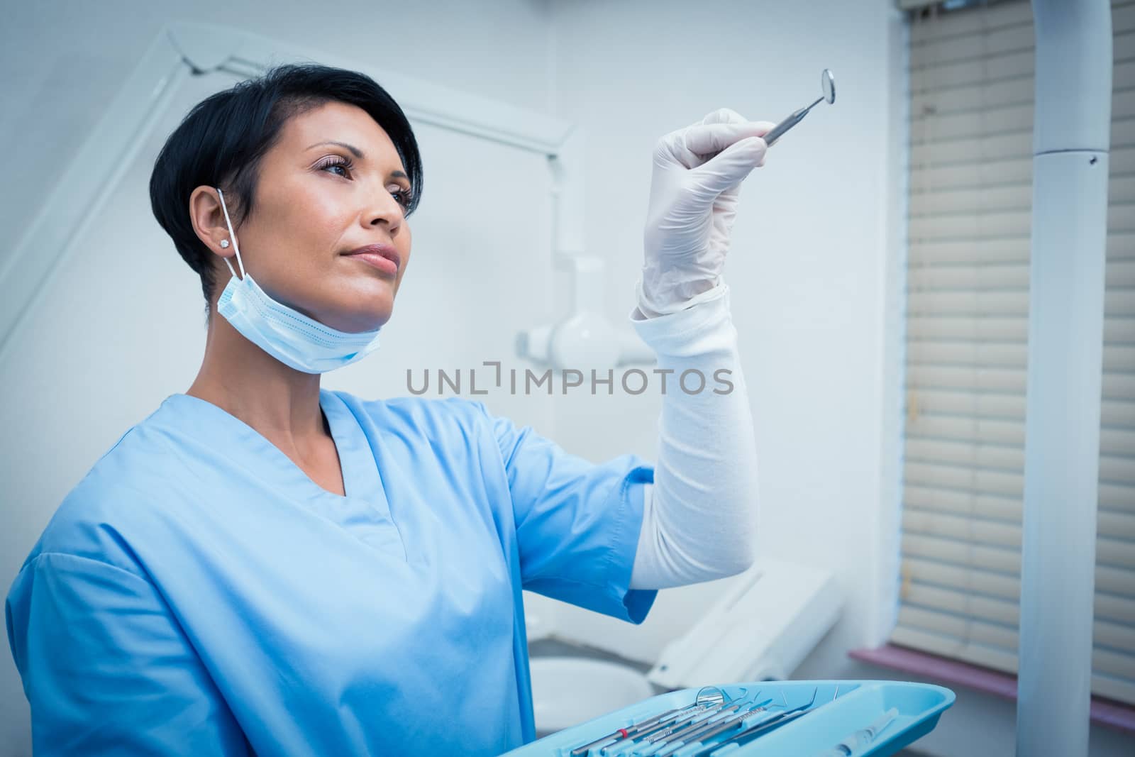 Female dentist holding dental tool by Wavebreakmedia