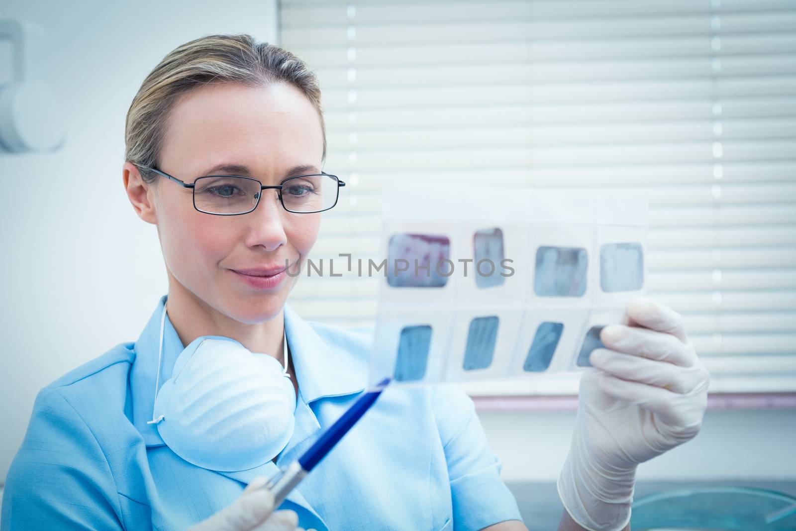 Concentrated female dentist looking at x-ray