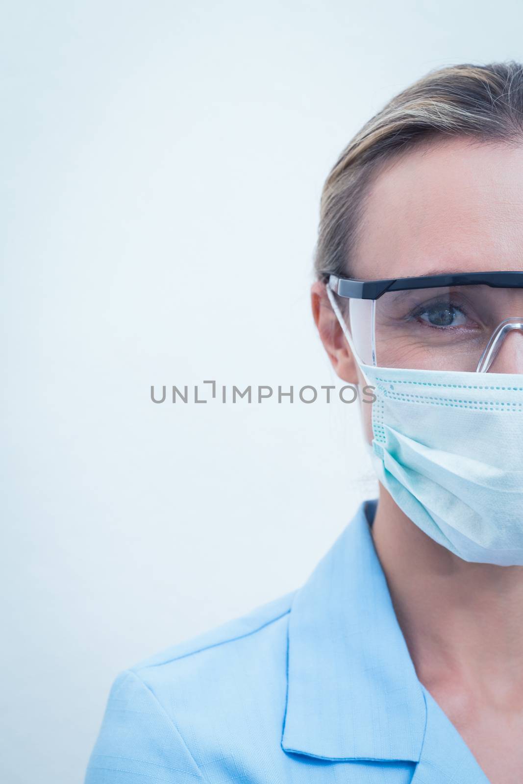 Female dentist wearing surgical mask and safety glasses by Wavebreakmedia