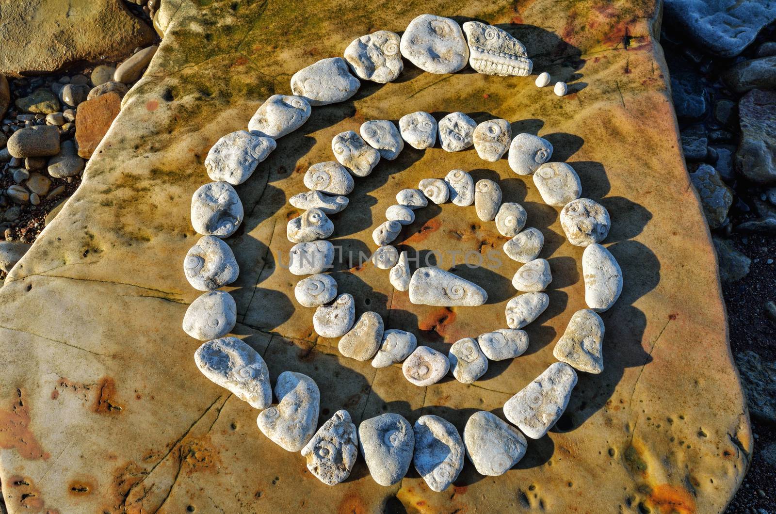 Spiral of pebbles on the sea boulder