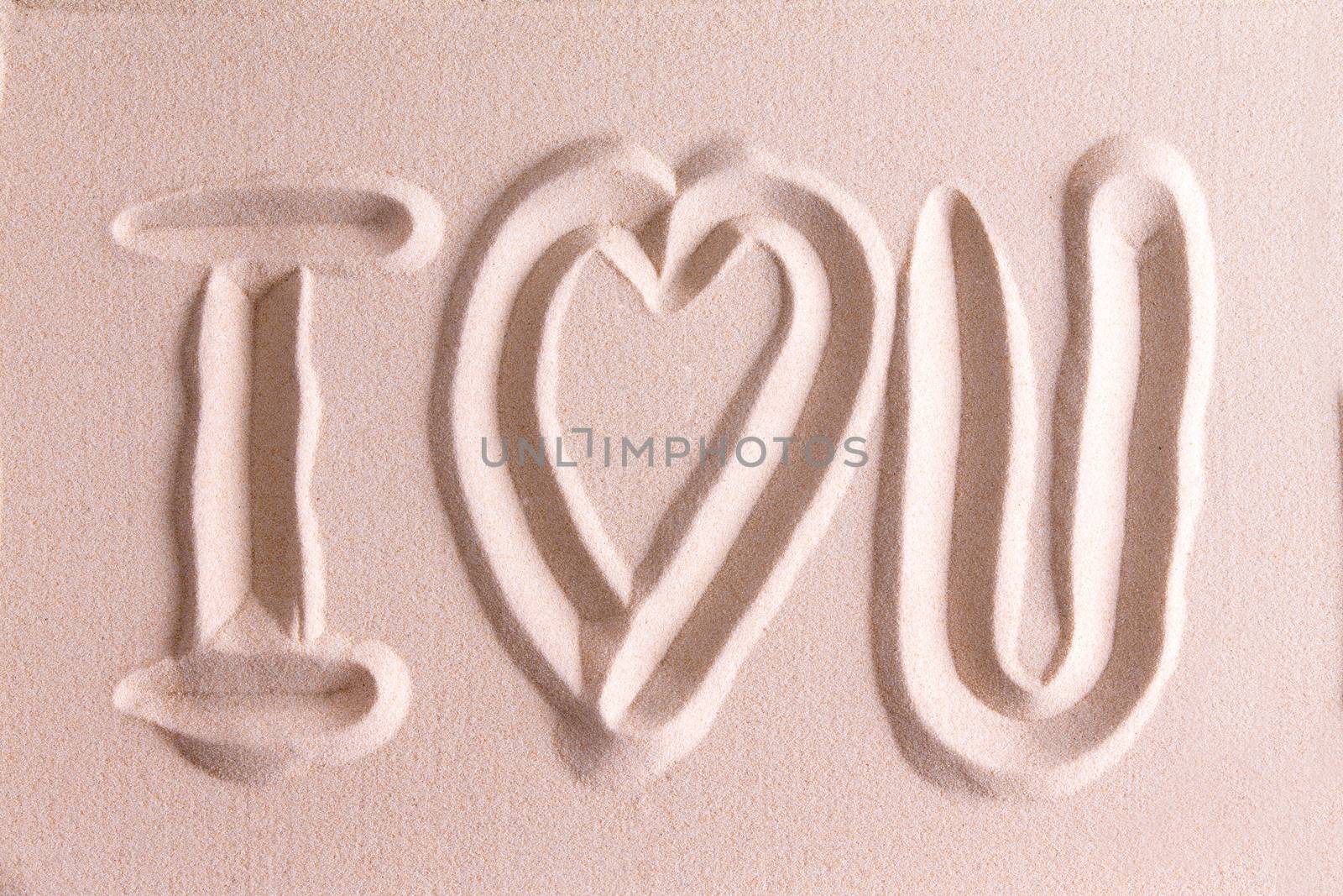 I Love You drawn in golden beach sand with a symbolic heart for romance and love for your sweetheart or Valentine in a simple elegant card design or background