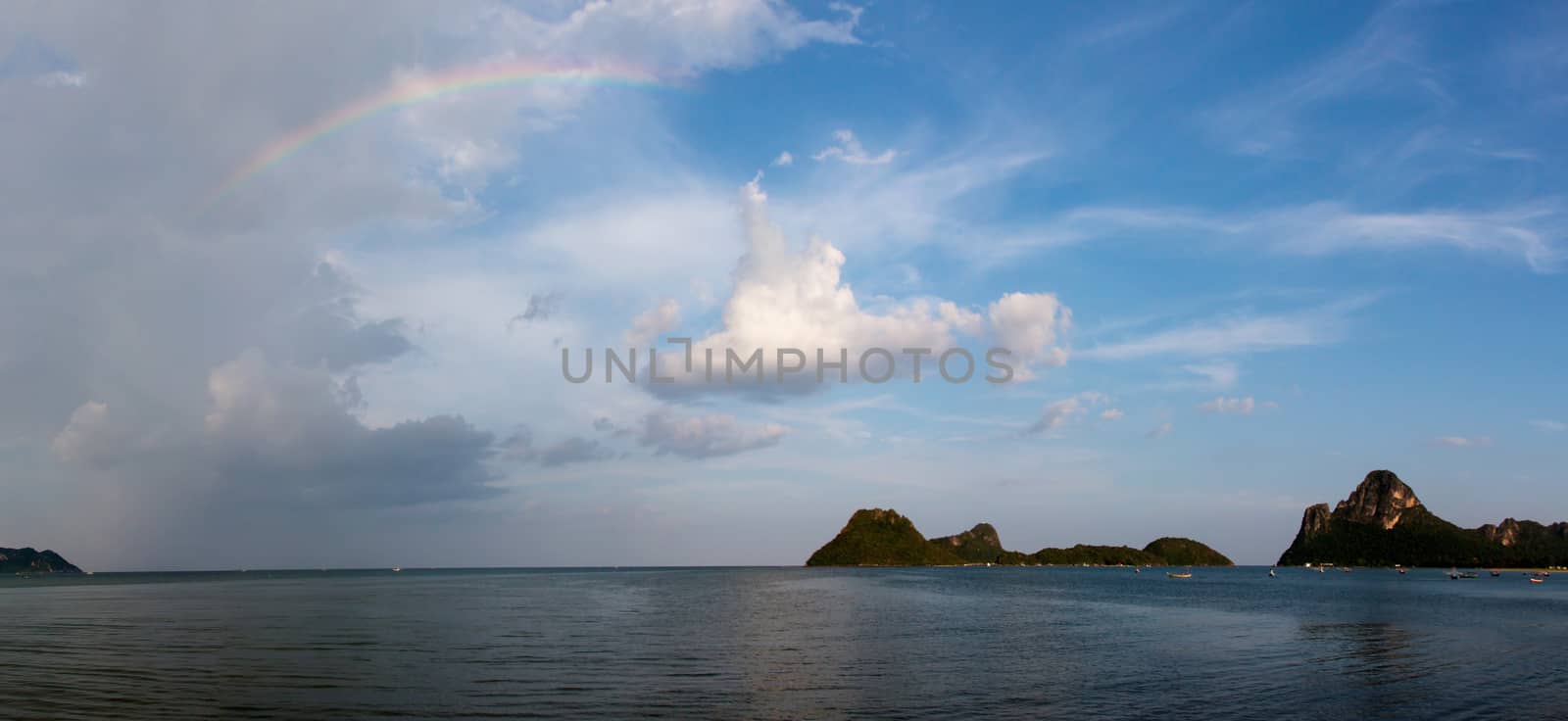 Rainbow on a blue sky with clouds after rain