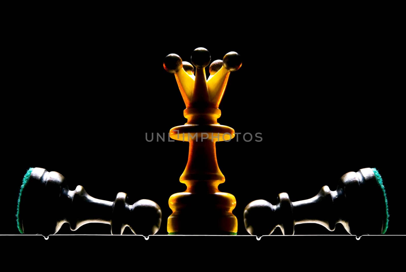 Chessmen on a chess board. A dark background and art illumination.