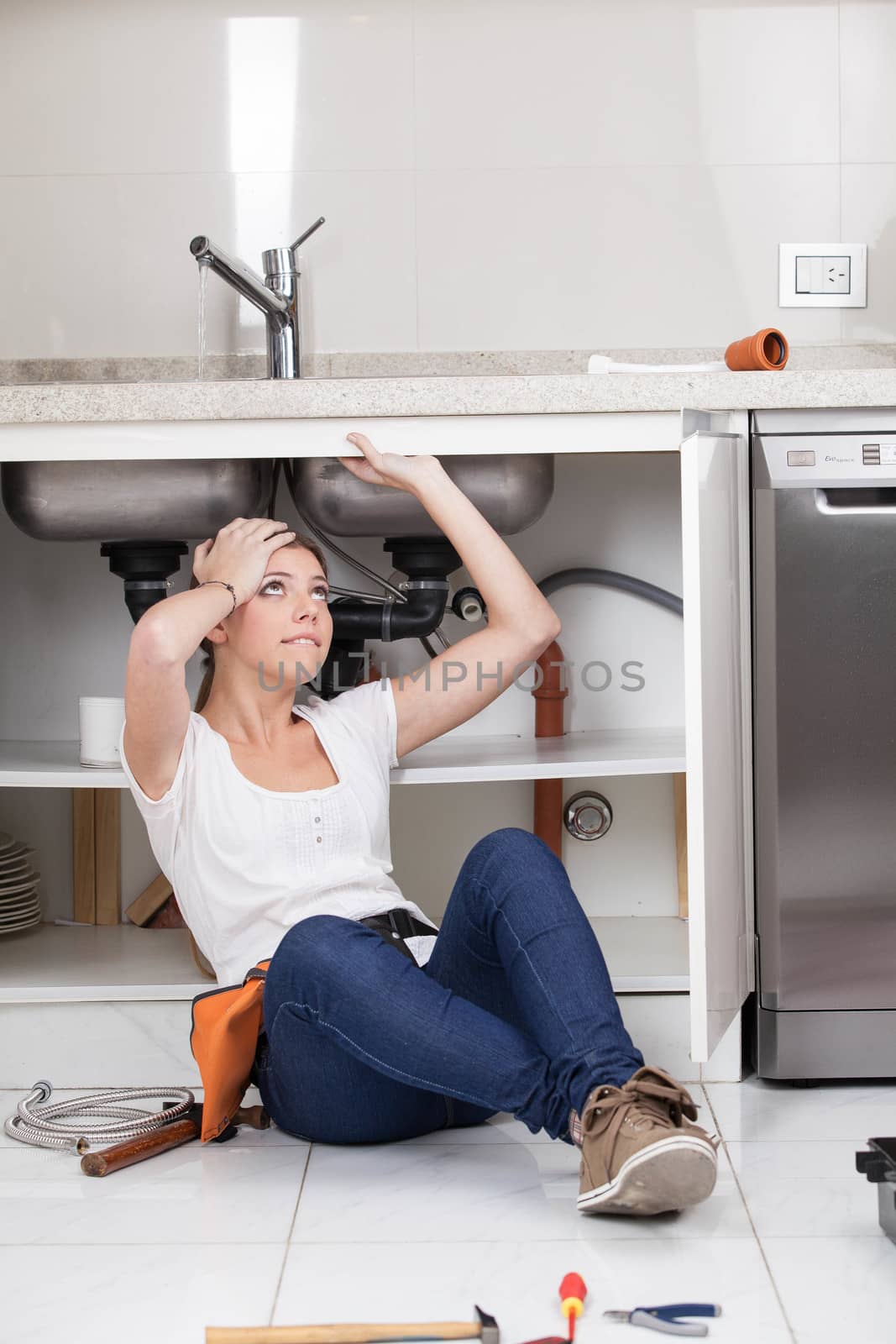 Woman working in the pipe of the kitchen