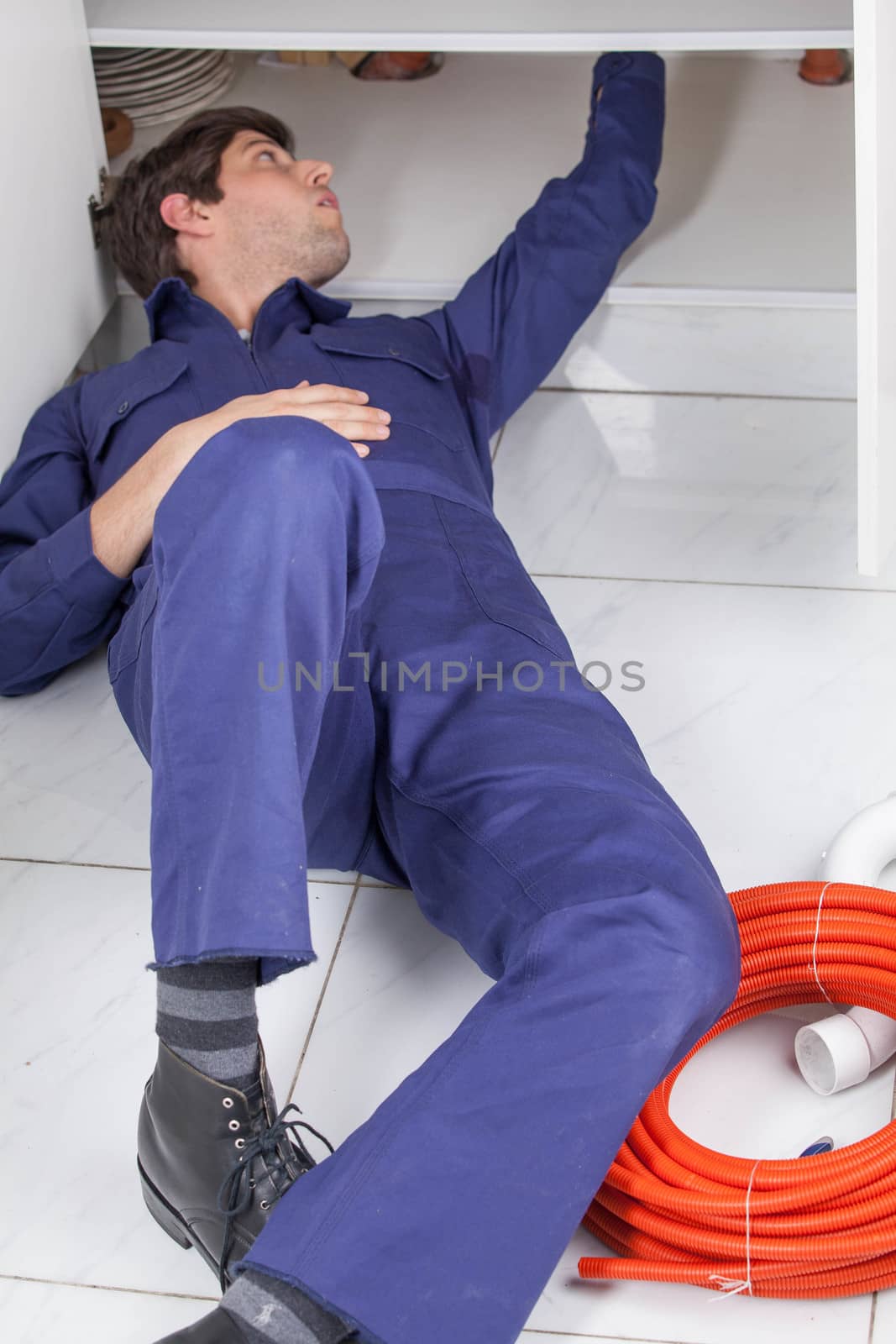 Plumber working lying on the floor
