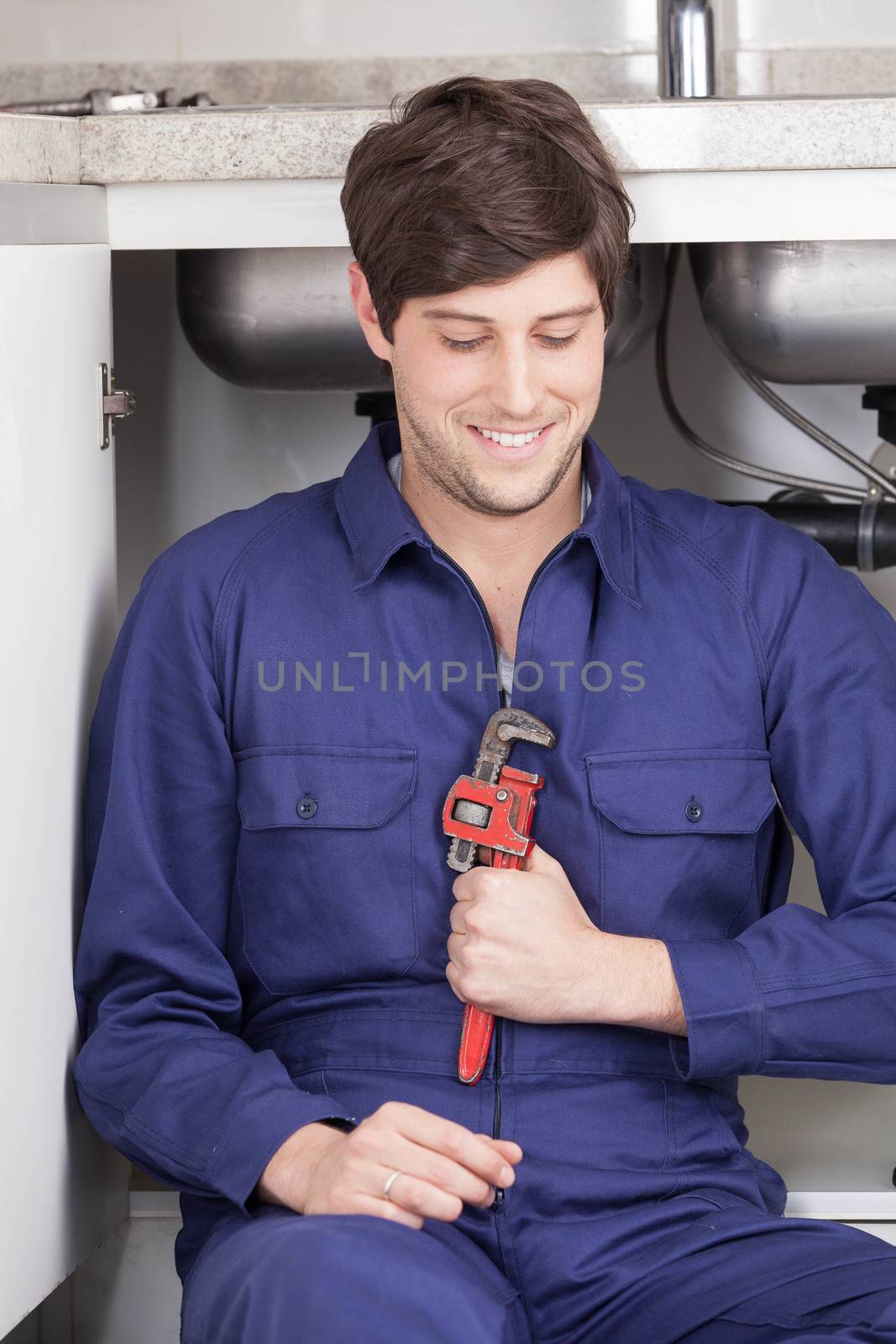 Happy plumber holding his wrench